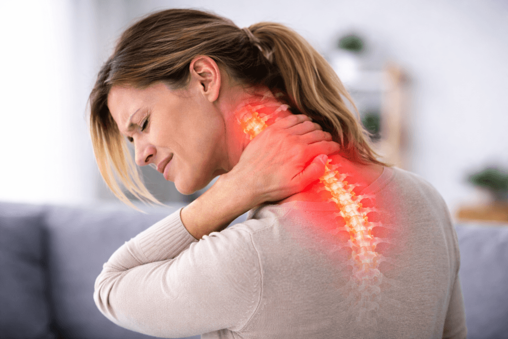 Femme qui se tient la nuque à cause d'une douleur cervicale